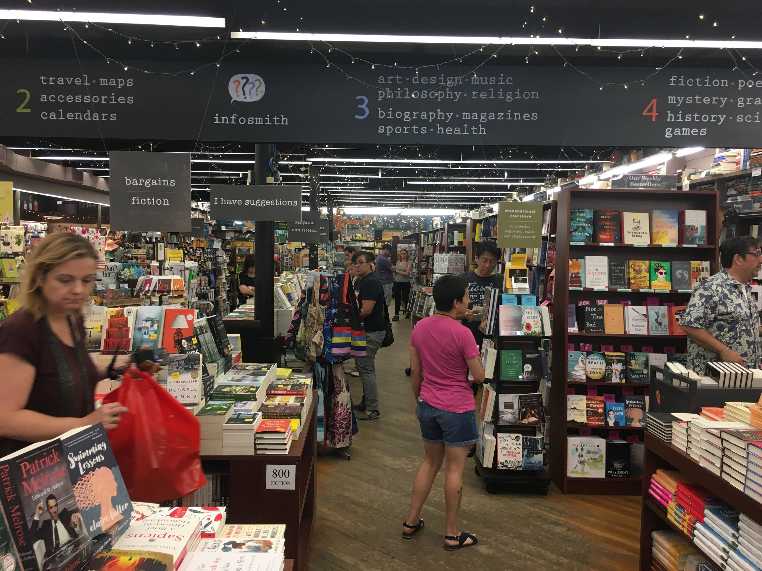 Inside Brookline Booksmith. The Transnational Literature Series display is to the right of the person wearing the pink t-shirt.&nbsp;